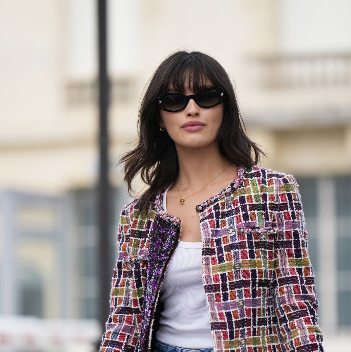 paris, france october 03 sarah ellen wears a colored checkered tweed jacket, a white tank top, blue ripped jeans, a chanel clutch, outside chanel, during the womenswear springsummer 2024 as part of paris fashion week on october 03, 2023 in paris, france photo by edward berthelotgetty images