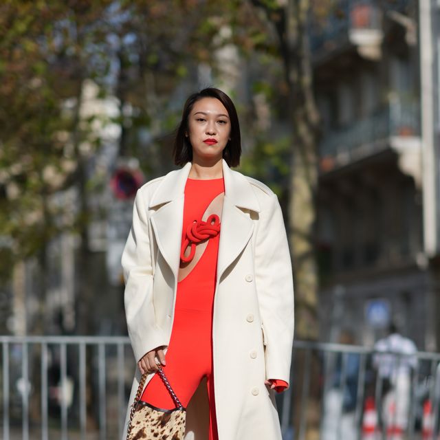 paris, france october 02 a guest wears a white trench coat, a red top with details and keyhole, flared pants, a brown leopard print bag, outside stella mccartney, during the womenswear springsummer 2024 as part of paris fashion week on october 02, 2023 in paris, france photo by edward berthelotgetty images