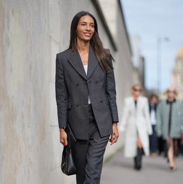 paris, france september 28 a guest wears a white top, a dark gray blazer jacket, flared suit pants, a black leather bag, white pointed shoes, outside givenchy, during the womenswear springsummer 2024 as part of paris fashion week on september 28, 2023 in paris, france photo by edward berthelotgetty images