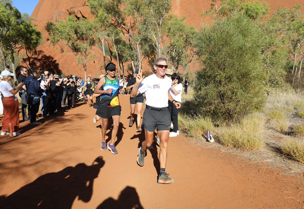 a group of people running on a dirt road