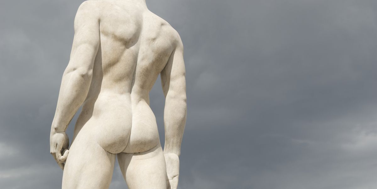 statue of a muscular male athlete warms his buns against moody gray sky