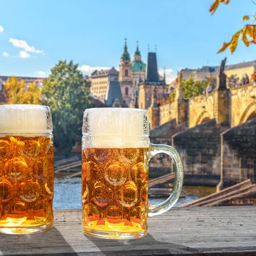 2 glasses of beer in the sunlight, in the background the view of prague