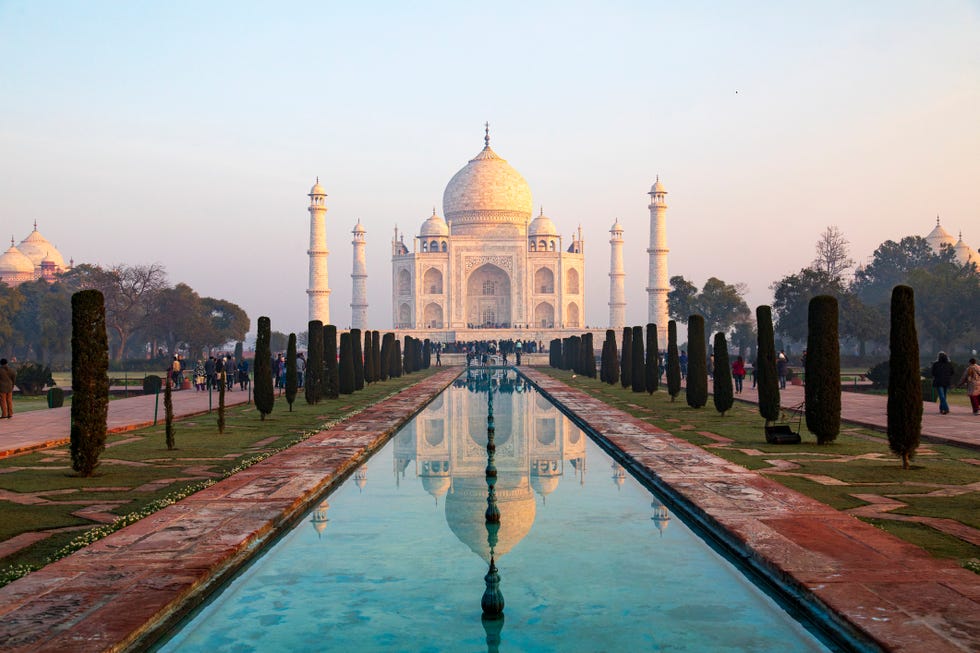 captured in the early morning light, this image showcases the taj mahal as its rarely seen, bathed in the warm glow of the rising sun with minimal haze, the iconic white marble monument stands in sharp contrast to the sky, fully revealing its intricate design and grandeur the photograph captures a tranquil moment at one of the worlds most celebrated landmarks, offering a unique perspective of the taj mahals timeless beauty