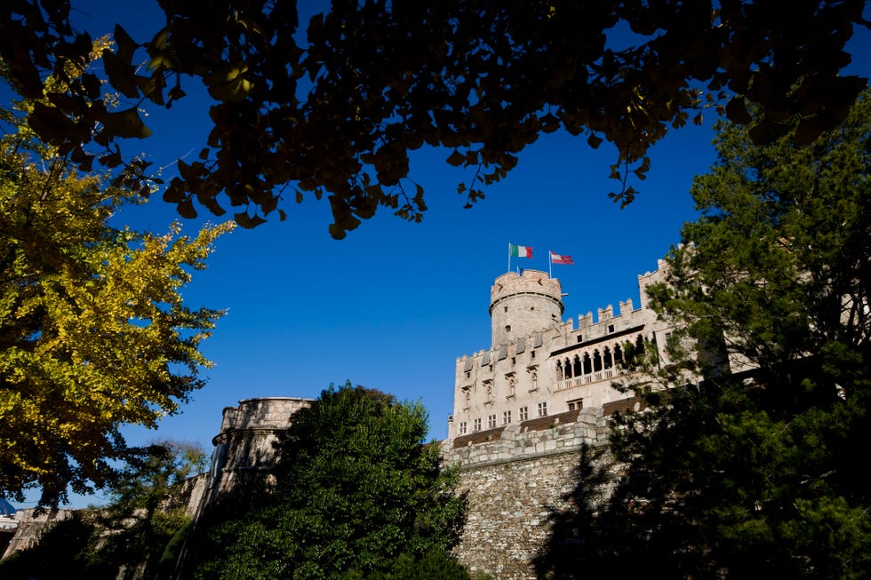 a prominent castle stands against a vibrant blue sky