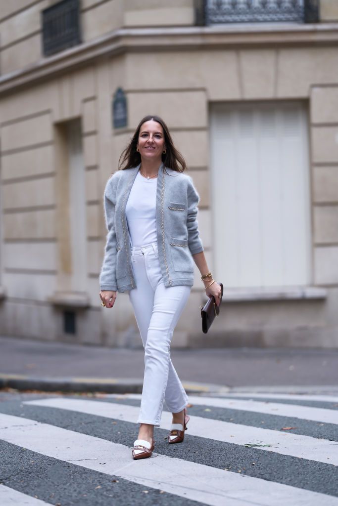 paris, france october 21 alba garavito torre wears a white t shirt from zara, a grey fluffy cashmere cardigan with chain detailed pockets from crush collection, white straight jeans from mother denim, brown and white leather slingback moccasins with heels from miu miu, a brown chocolate leather envelope clutch with gold buckle detail from octogony, during a street style fashion photo session, on october 21, 2023 in paris, france photo by edward berthelotgetty images