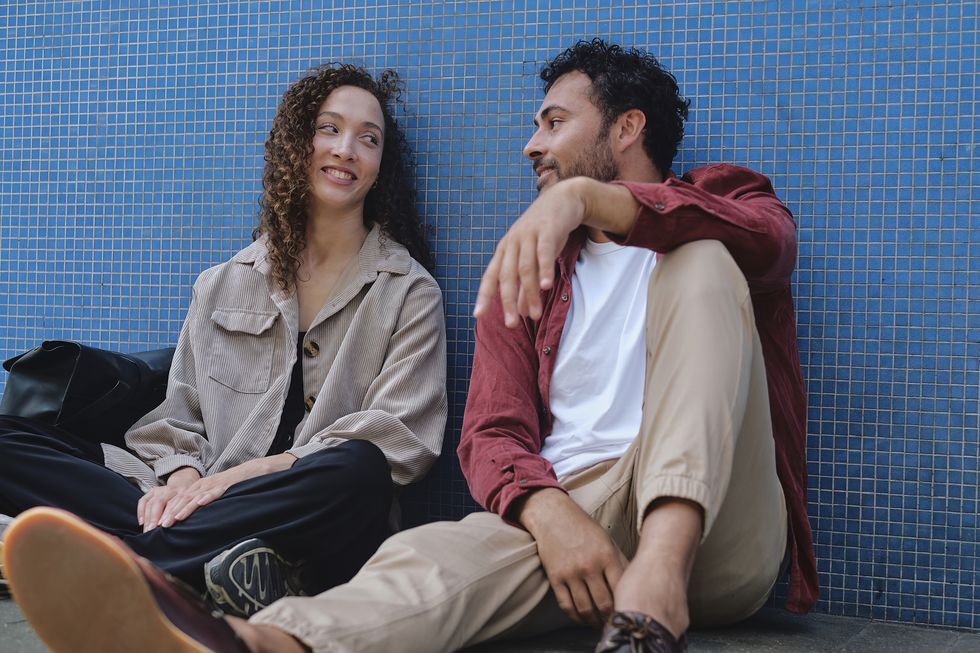 a man and woman sitting on the ground