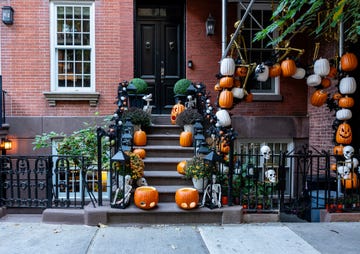 colorful pumpkins and halloween decorations on the stairs of an old brownstone home in upper east side, new york city