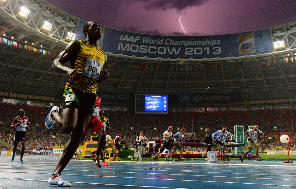 topshot jamaicas usain bolt wins the 100 metres final at the 2013 iaaf world championships at the luzhniki stadium in moscow on august 11, 2013 while a lightning strikes in the sky bolt timed a seasons best 977 seconds, with american justin gatlin claiming silver in 985sec and nesta carter, also of jamaica, taking bronze in 995sec afp photo  olivier morin photo by olivier morin  afp photo by olivier morinafp via getty images
