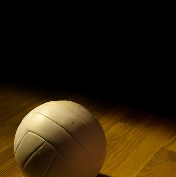 volleyball left on the court and under the lights after a game