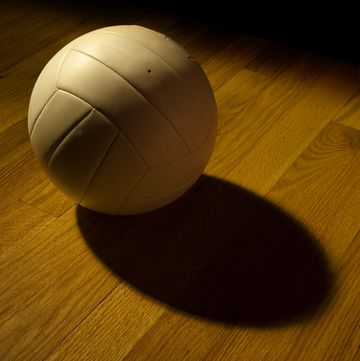 volleyball left on the court and under the lights after a game