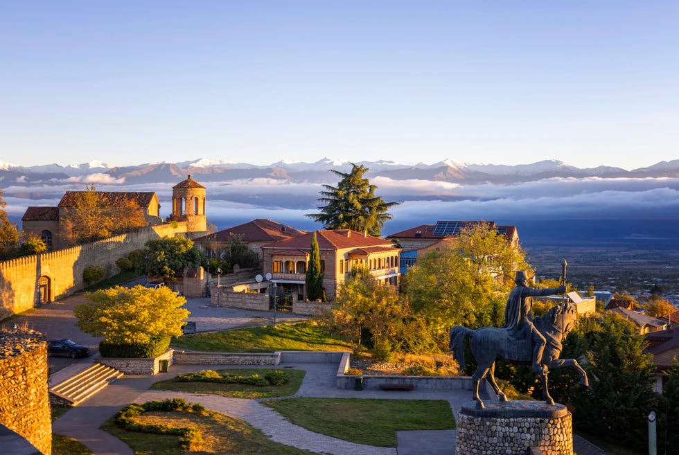 the fortress is also known as batonis tsikhe the picture is taken at dawn, with caucasus mountains on the background date 16 october 2023