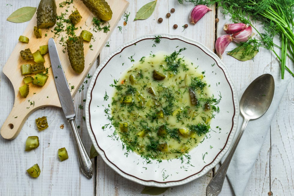 ways to use pickle juice adding pickles and pickle juice to bowl of soup with herbs