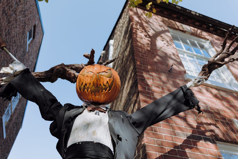 low angle view of pumpkin scarecrow halloween decor outside of townhouse