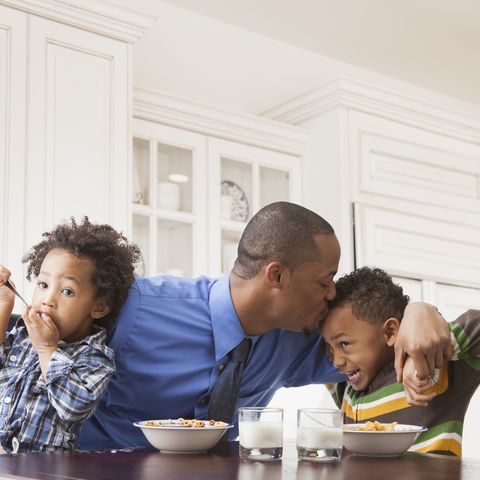 father kissing sons at breakfast table men's health hunger