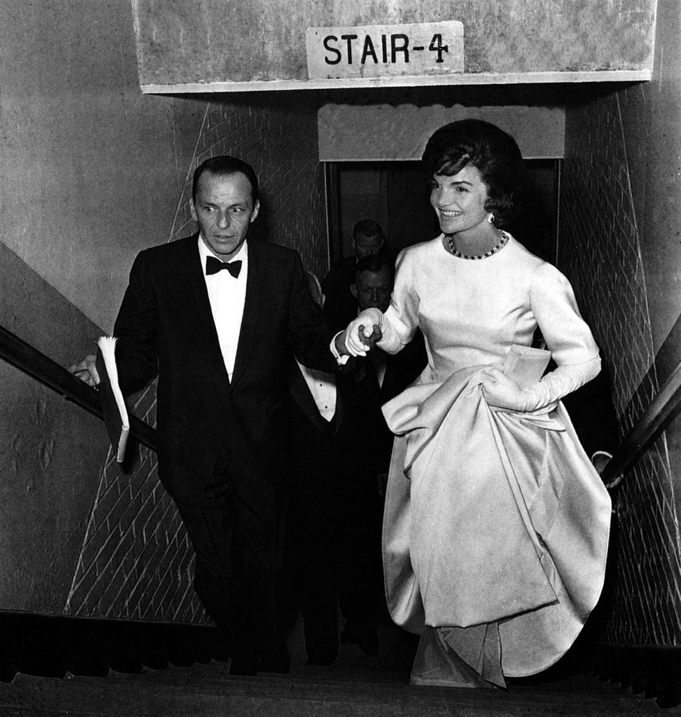 Frank Sinatra escorts Jacqueline Kennedy up the stairs during the inaugural gala at the National Guard Armory in Washington, D.C. on January 19, 1961