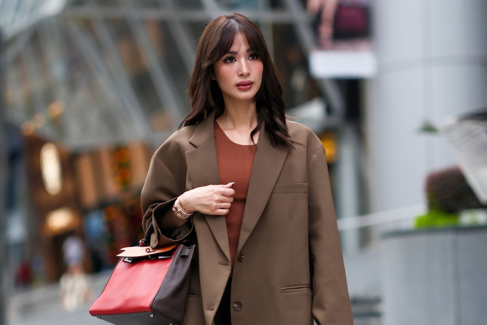 singapore, singapore november 16 heart evangelista wears a brown oversized blazer jacket from frankie shop, a dark orange top, a red and orange hermes leather birkin bag, a long black skirt, sandals with golden details from alaia, on november 16, 2023 in singapore photo by edward berthelotgetty images
