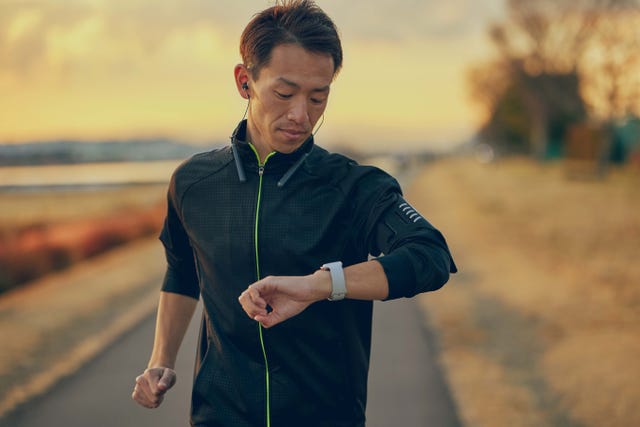 athlete checking watch while running outdoors