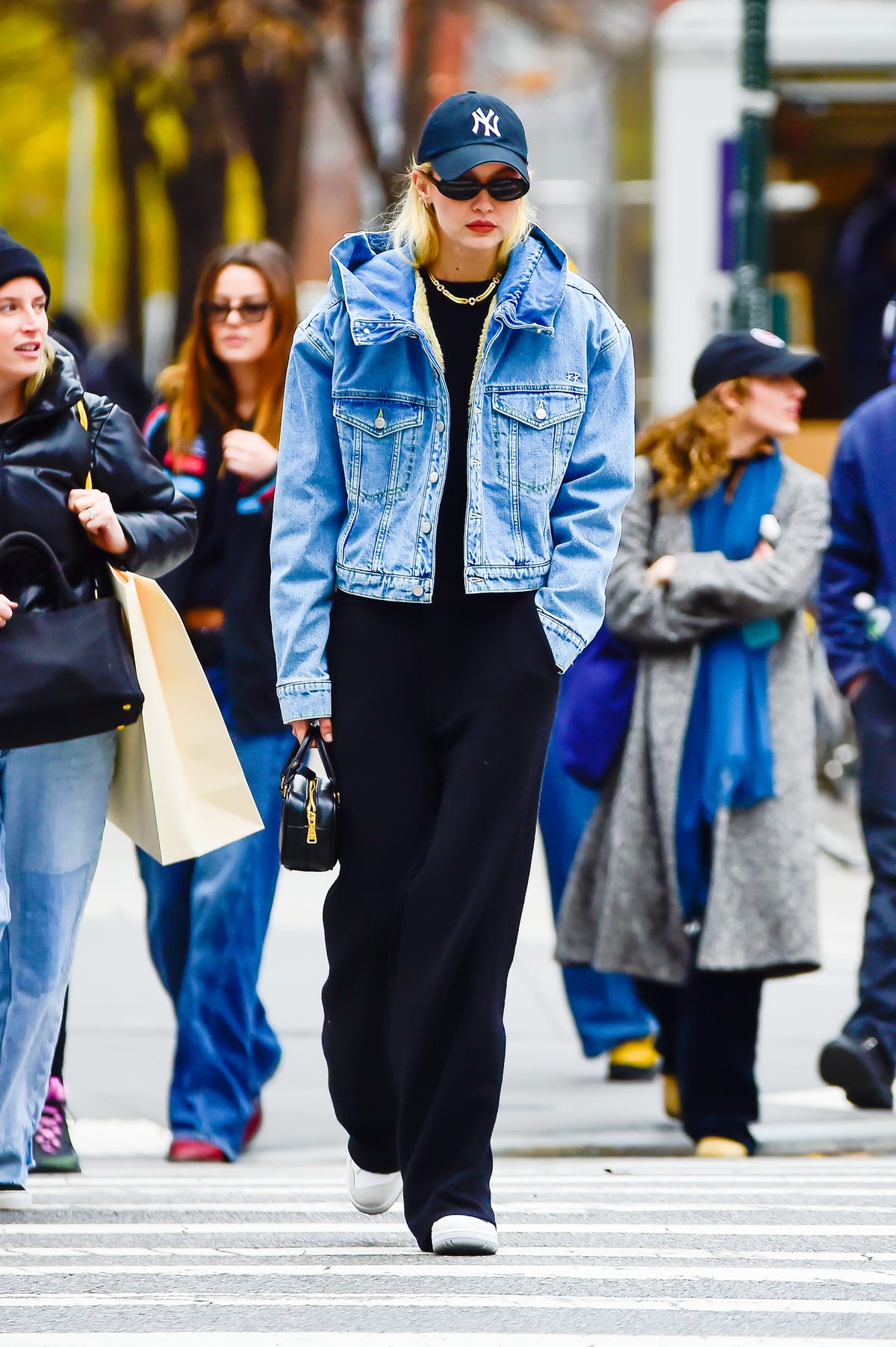 Gigi Hadid sports a pink and blue hoodie with a denim vest and