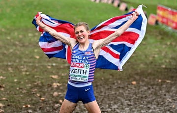 megan keith holds up union jack flag after winning a cross country running race