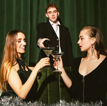 young elegant man pouring a champagne for ladies