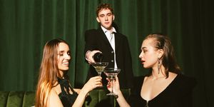 young elegant man pouring a champagne for ladies