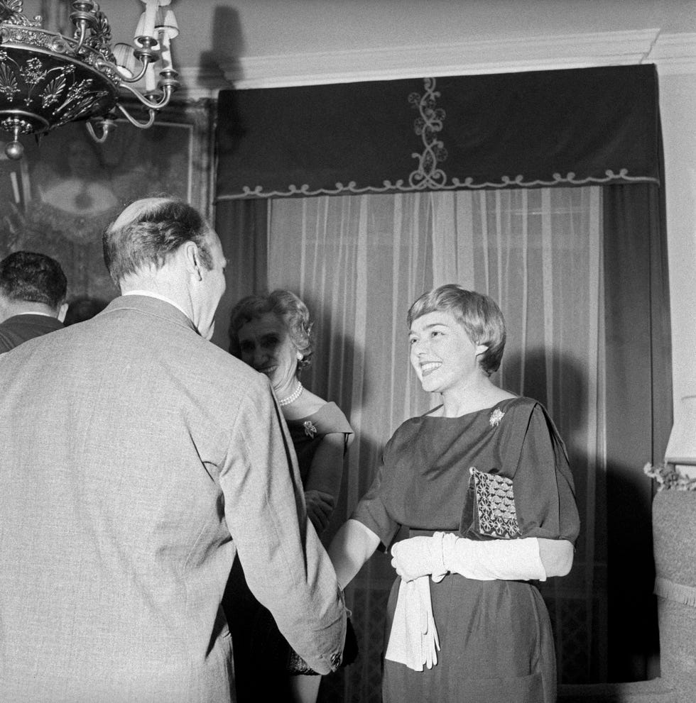 italian writer and journalist fernanda pivano shaking hands with a man at a party in honour of german writer alfred andersch and french writer michel butor milan, 9th november 1959