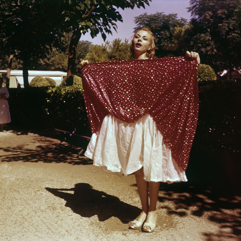 italian actress and tv presenter sandra milo salvatrice elena greco lifting up the wet skirt of her dress venice, 1956 photo by emilio ronchinimondadori via getty images