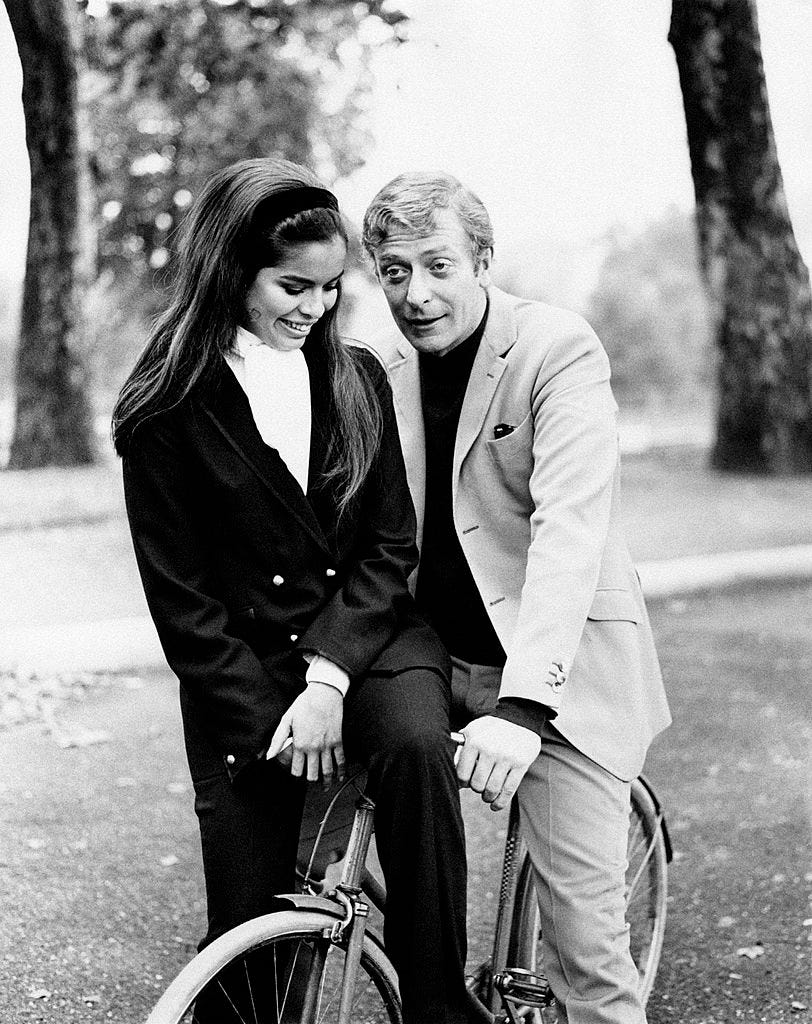 Michael Caine and Bianca De Macias smiling in a park