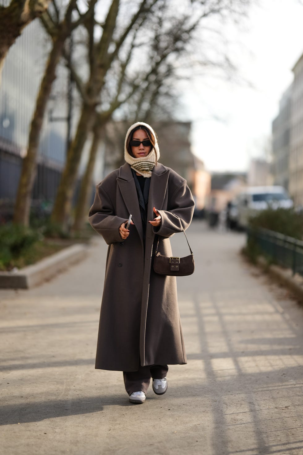 paris, france january 20 a guest wears a white hood  balaclava, a brown oversized long trench coat, a brown suede bag, sneakers shoes, outside kolor, during the menswear fallwinter 20242025 as part of paris fashion week on january 20, 2024 in paris, france photo by edward berthelotgetty images