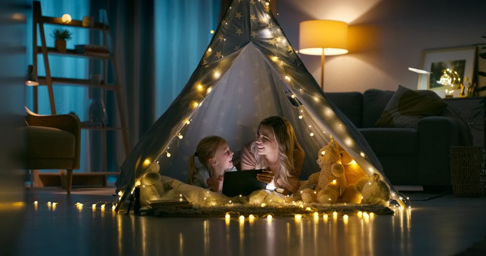 mother and daughter watching an ipad in a den at home