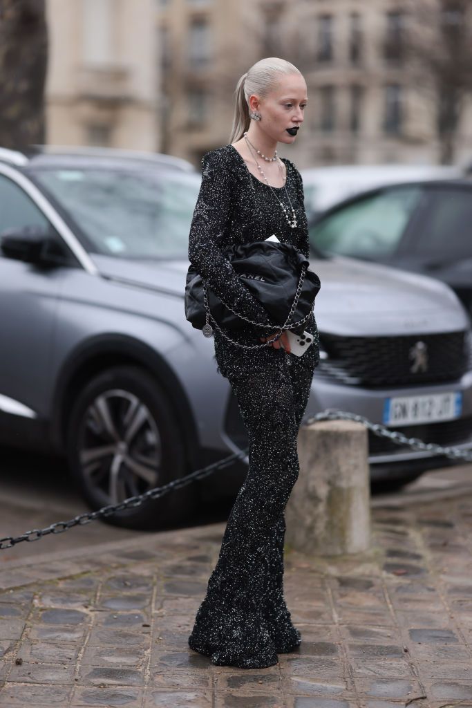 paris, france january 23 fashion week guest is seen wearing a black glitter top with round neckline and long sleeves, the matching trousers with black glitter, long chains with pearls from chanel and a black leather handbag from chanel during the chanel show haute couture springsummer 2024 as part of paris fashion week on january 23, 2024 in paris, france photo by jeremy moellergetty images
