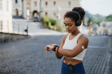 beautiful diabetic girl in activewear checking her performance on smartwatch diabetic teenage girl with continuous glucose monitor and insulin pump exercising concept of daily life with chronic illness, diabetes for teenagers