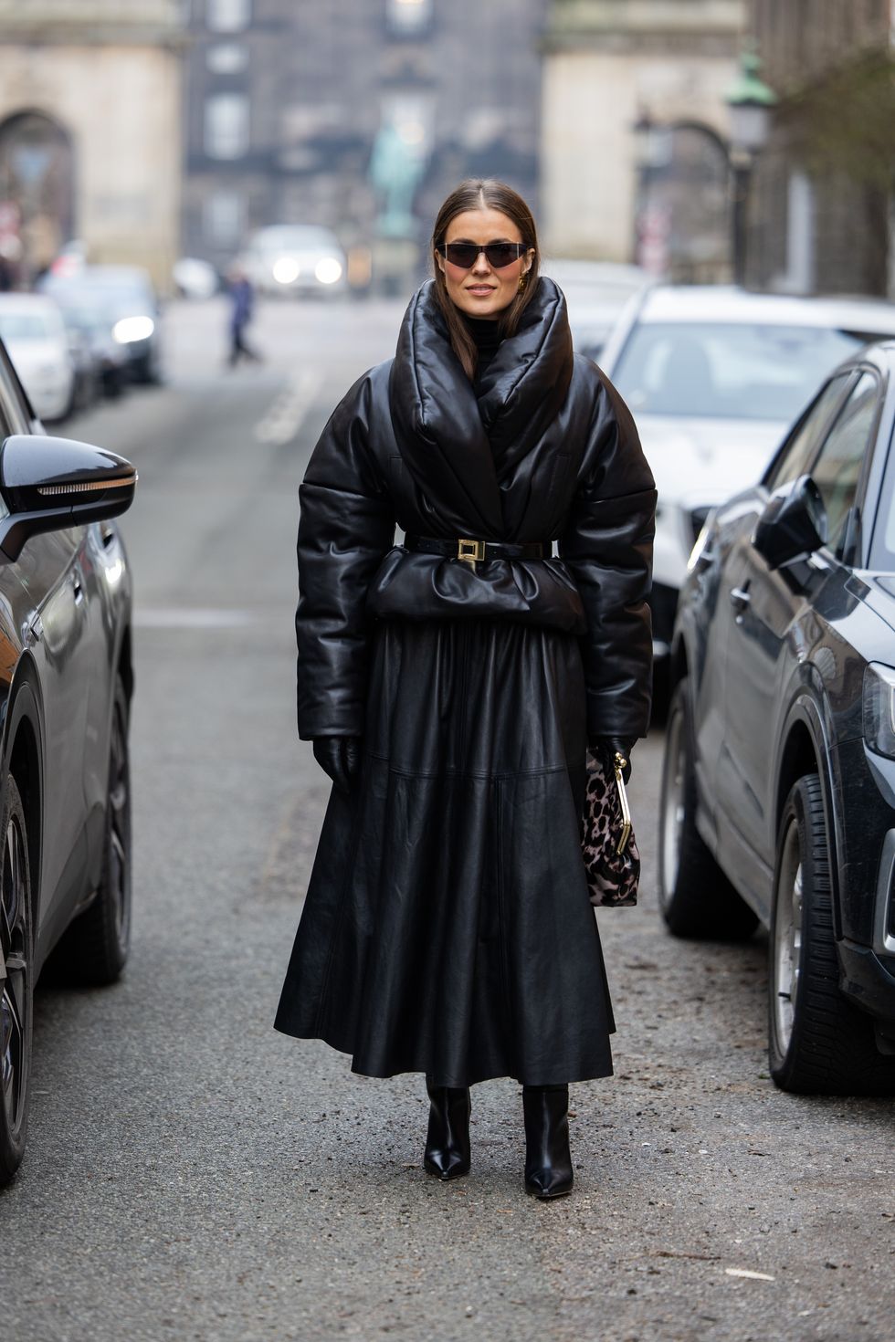 copenhagen, denmark january 30 nina sandbech wears black puffer jacket, pleated leather skirt, sunglasses, gloves, bag with print, boots, belt outside lovechild 1979 during the copenhagen fashion week aw24 on january 30, 2024 in copenhagen, denmark photo by christian vieriggetty images