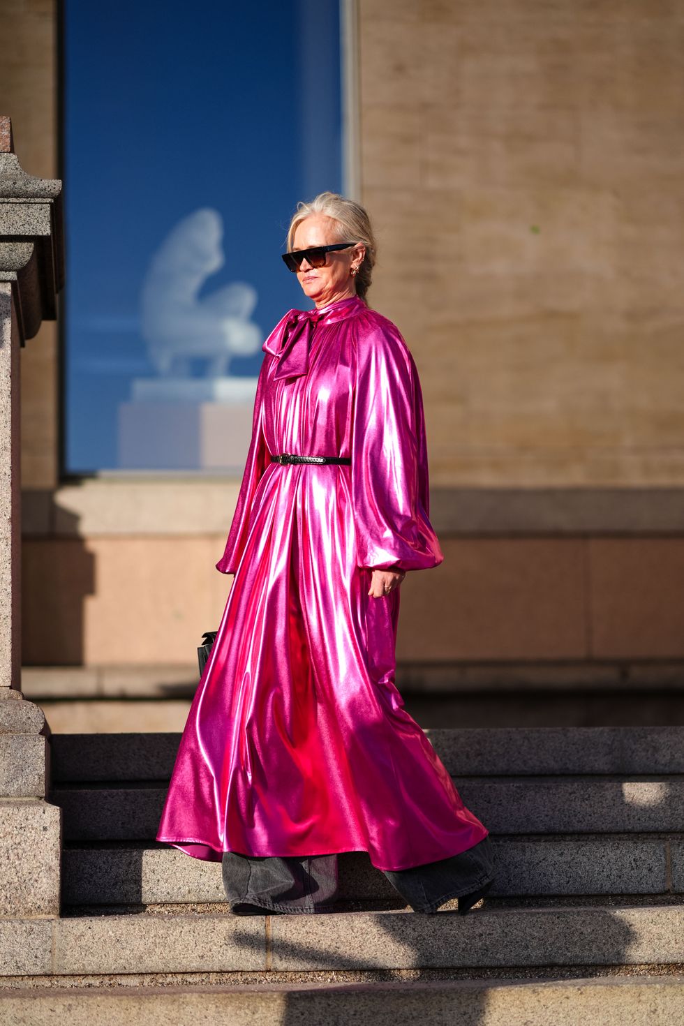 copenhagen, denmark february 01 a guest wears sunglasses, a neon pink lustrous shiny silk pleated and gathered long jumpsuit with flared pants and sleeves, a hermes bag, outside marimekko, during the copenhagen fashion week aw24 on february 01, 2024 in copenhagen, denmark photo by edward berthelotgetty images