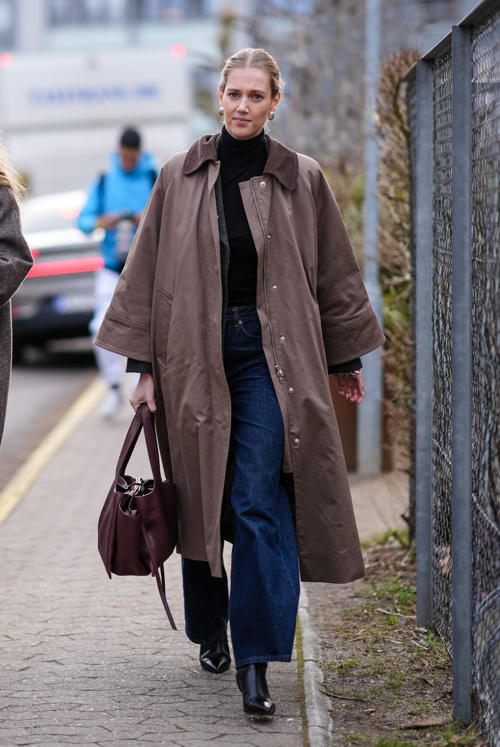 copenhagen, denmark january 31 a guest wears golden earrings, a black turtleneck , a brown long coat , blue flared denim jeans pants , a brown leather bag, pointed leather shoes, outside skall studio, during the copenhagen fashion week aw24 on january 31, 2024 in copenhagen, denmark photo by edward berthelotgetty images