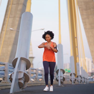 person jogging on a bridge with a large suspension structure in the background person jogging on a bridge with a large suspension structure in the background