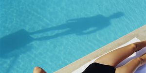 woman lying by side of pool, elevated view