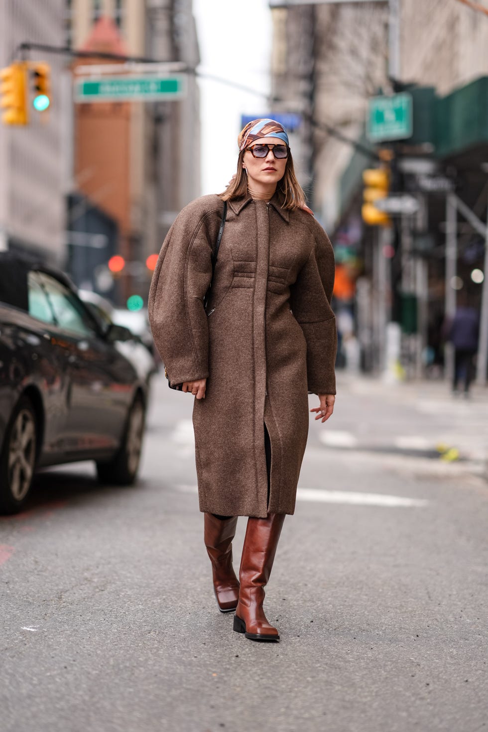 new york, new york february 11 a guest wears a colored bandanna  scarf over the head, a brown winter long coat with puff sleeves, a black leather bag, knee high brown leather boots, outside altuzarra, during new york fashion week, on february 11, 2024 in new york city photo by edward berthelotgetty images