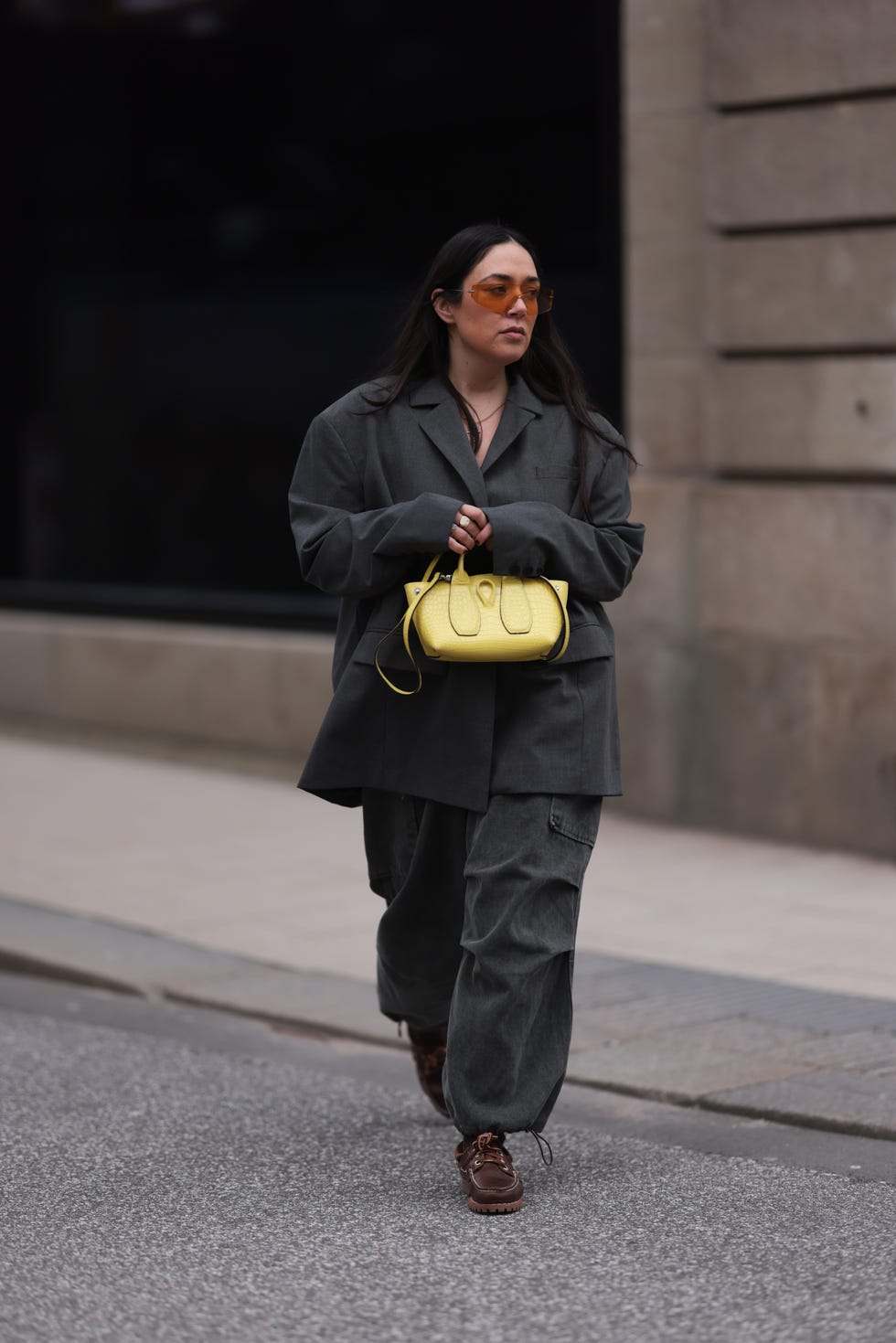 hamburg, germany february 23 jennifer casimiro seen wearing kaleos orange sunglasses, silver necklace, zara grey oversized blazer jacket, source unknown grey denim parachute pants, gold  colorful rings, calzedonia black wool socks, longchamp yellow leather bag and timberland brown leather shoes, on february 23, 2024 in hamburg, germany photo by jeremy moellergetty images