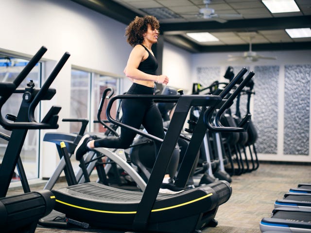 athletic woman running on a treadmill in a gym