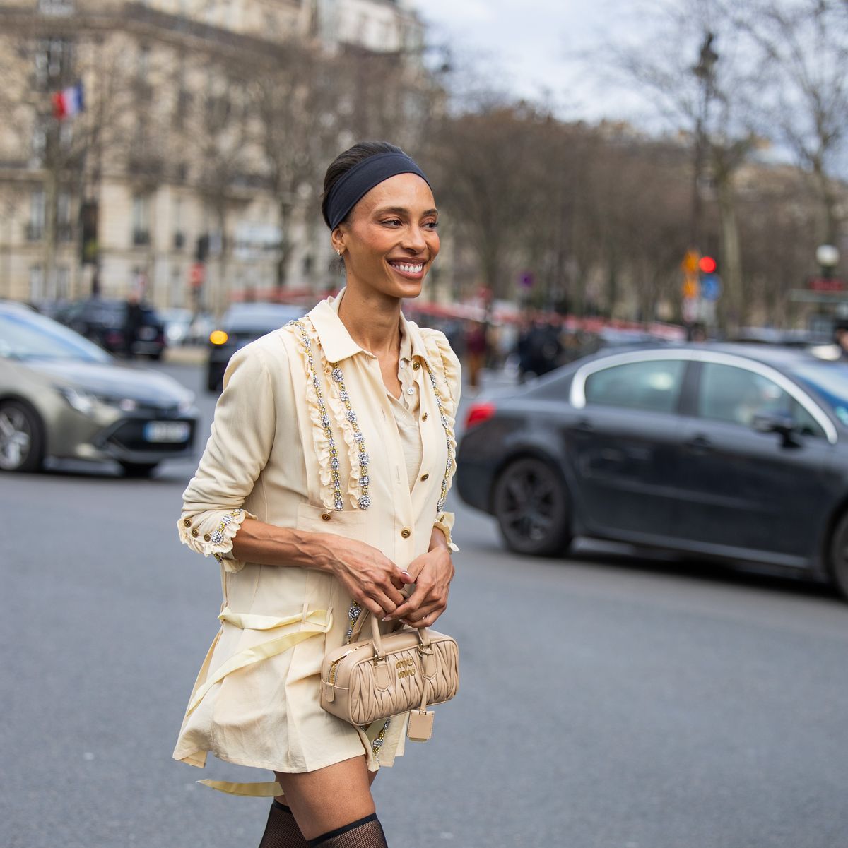 paris, france march 05 a guest wears black head band, beige button shirt, bag, over knee tights outside miu miu during the womenswear fallwinter 20242025 as part of paris fashion week on march 05, 2024 in paris, france photo by christian vieriggetty images