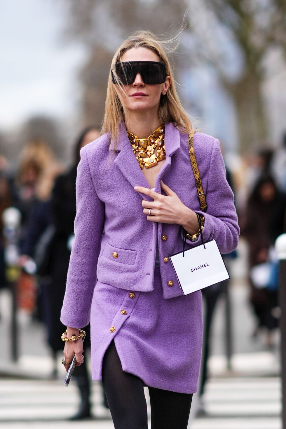paris, france march 05 a guest wears sunglasses, a golden necklace, a purple fluffy jacket , mini skirt, black tights, knee high black boots , outside chanel, during the womenswear fallwinter 20242025 as part of paris fashion week on march 05, 2024 in paris, france photo by edward berthelotgetty images