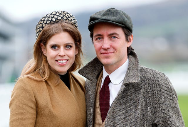 a couple dressed in vintagestyle clothing poses outdoors
