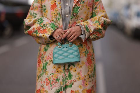 munich, germany march 23: karin teigl seen wearing loewe yellow sunglasses, agolde light grey denim buttoned jeans shirt, matching agolde light grey denim straight leg pants, stine goya yellow with colorful flower embroidered pattern long coat, louis vuitton light blue leather alma mini bag, bulgari bzero diamond yellow gold ring and oura gold smart fitness ring, on march 23, 2024 in munich, germany. (photo by jeremy moeller/getty images)