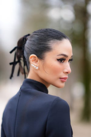 paris, france february 27 heart evangelista wears bejeweled diamond earrings, lipstick, make up , a ponytail, a turtleneck collar navy blue dress, outside dior, during the womenswear fallwinter 20242025 as part of paris fashion week on february 27, 2024 in paris, france photo by edward berthelotgetty images