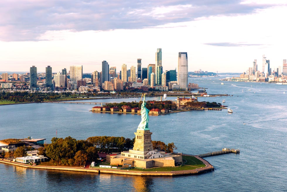 statue of liberty and jersey city skyline seen from helicopter, new york city, usa