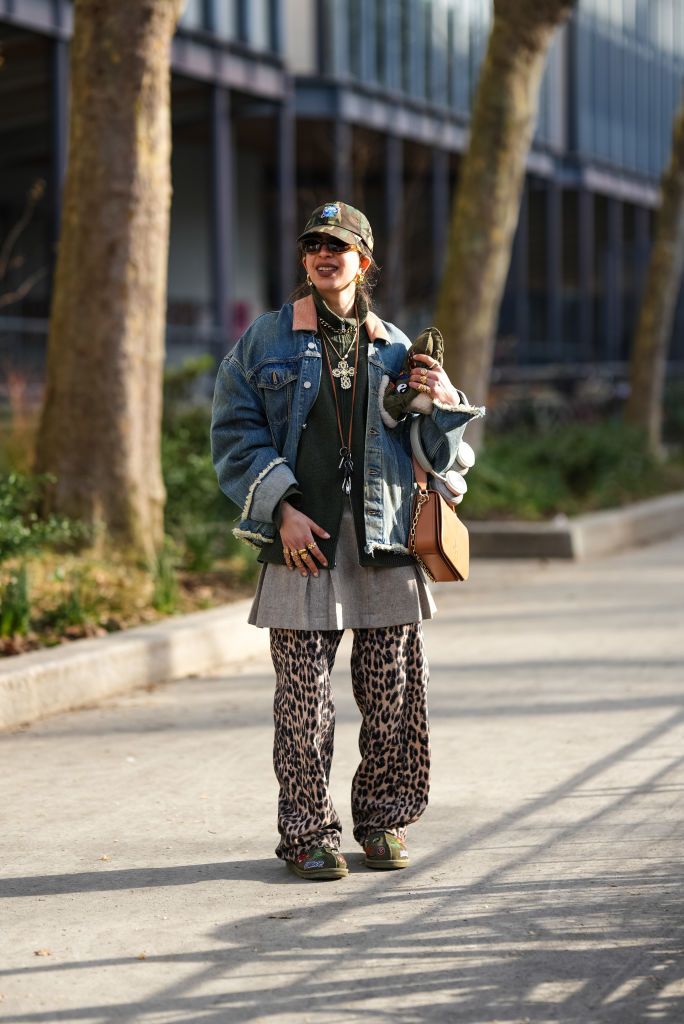paris, france january 20 a guest wears a cap, a blue denim jacket , a brown leather bag, wide leg flowing pants with leopard print, outside kolor, during the menswear fallwinter 20242025 as part of paris fashion week on january 20, 2024 in paris, france photo by edward berthelotgetty images