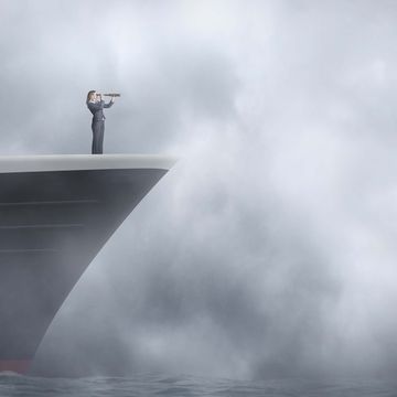 woman standing at bow of ship looking through the fog