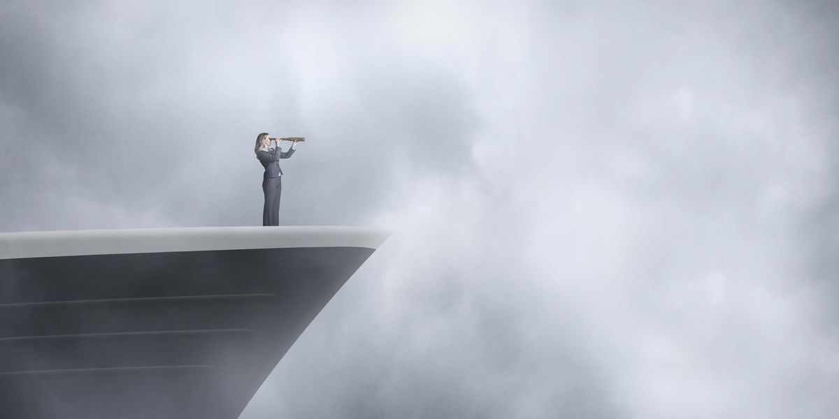woman standing at bow of ship looking through the fog