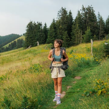 Woman hiking in Swiss Alps in summer through the meadow determined cheerful woman hiking in swiss alps in summer